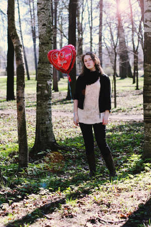 girl with heart balloon in the spring parkの写真素材