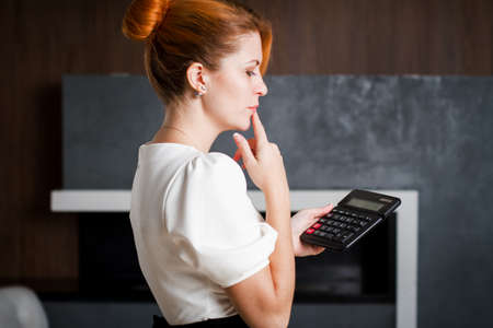 Businesswoman thinking looking at calculatorの写真素材