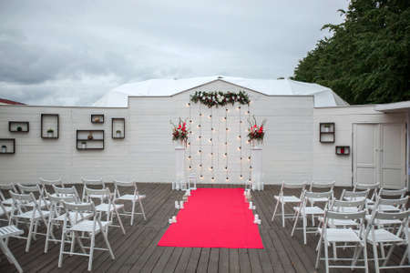 Beautiful place with floral decorations for outside wedding ceremony in open air.