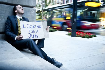 Young businessman holding sign Looking for a jobの写真素材