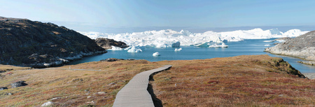 a wooden walkway towards Ilulissat Ice Fjord (jakobshavn) near Ilulissat in Summerの写真素材