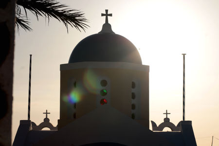 Blue dome of church as silhouette again the sunrise in Santorini, Greece.の写真素材