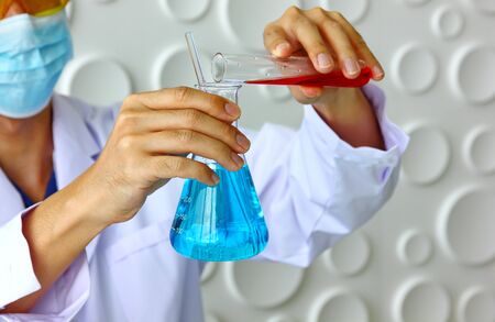 handsome researcher in white suit is mixing new drug for take care  pet or people  in laboratory  on white background.の写真素材