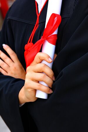 the graduate holding her graduation certificate attach her mind and very happy  in her success.の写真素材