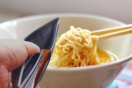 hand open empty black money wallet with instant noodle in bowl.の写真素材