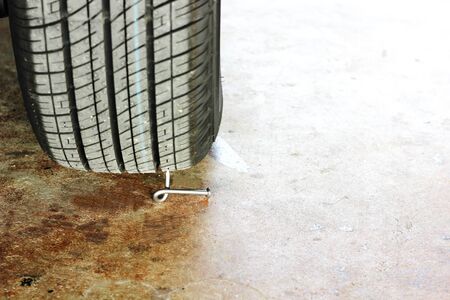 twist nail trap under car wheelの写真素材