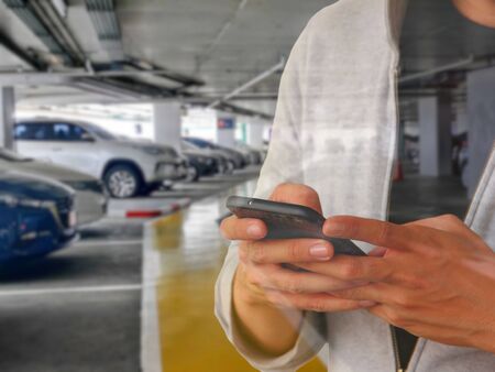 man is using mobile phone call grab car or taxi at meeting point.の写真素材