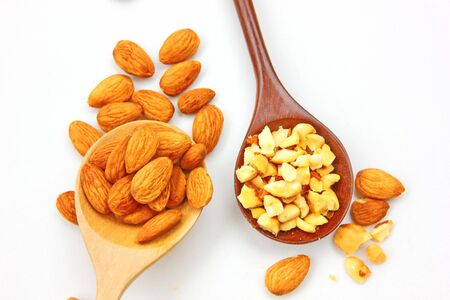 group of brown almond seed and pieces almond  high vitamin on wooden spoon isolate on white background.の写真素材