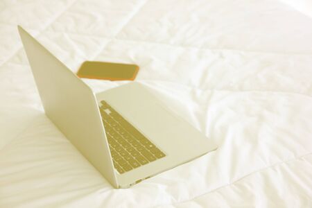 laptop and smart phone on bedの写真素材