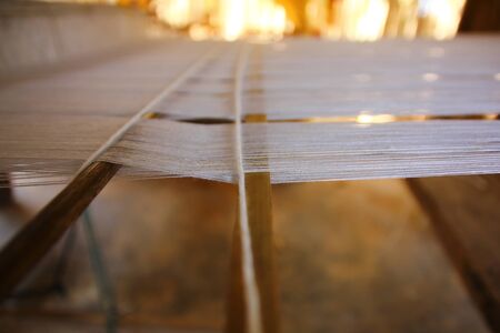 close up white yarns on wood loom weaving ready to produce.の写真素材