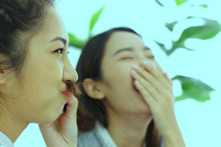 two asian tenage in enjoy monent one  makes  her hair  is mustacheの写真素材