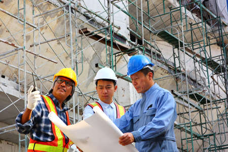 group of engineers standing in front of the project  with metal scaffolding on building background