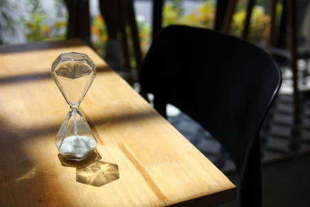 glass sanr watch low key light under lath on wood tableの写真素材