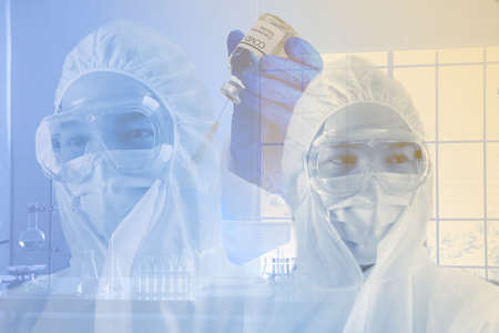 the reasearcher,scientist,doctor,or chemist in virus protective suit  with hand using syringes...