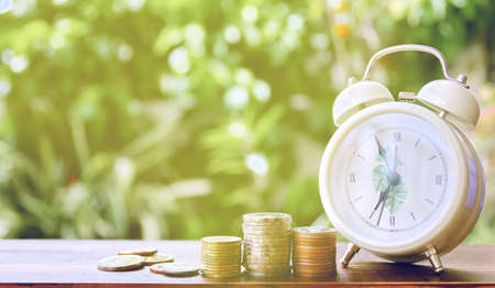 coins stacking with white alarm watch,saving concept