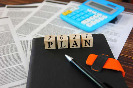 the text 2021 with letter plan on wooden cube on dairy , business planning . business concept