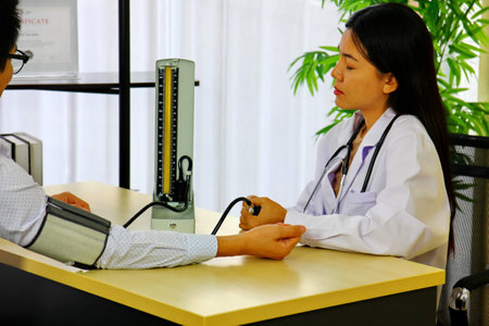 the doctor using blood pressure moniter measuring the patient blood pressure in hospitalの写真素材