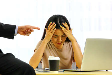 angry boss pointing index finger to the secretary. woman worker in depress momentの写真素材