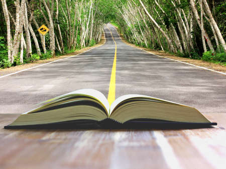 book open on wood table with bookshelf backgrund.の写真素材