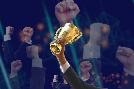 business man holding golden trophy in hand with business handful raised, business conceptの写真素材