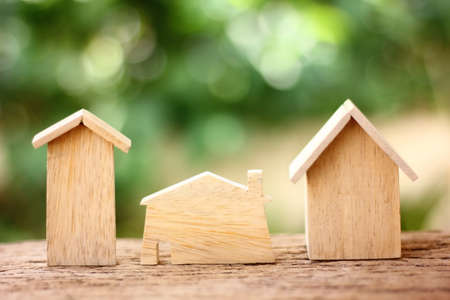 wooden model home on retro wood floor with blur green backgroundの写真素材