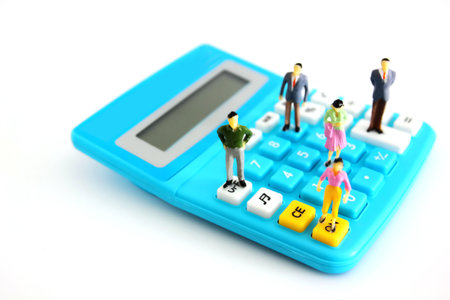 miniature people model standing on calculator button isolate on whiteの写真素材
