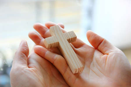 cross on Christian woman hand while praying God protectの写真素材