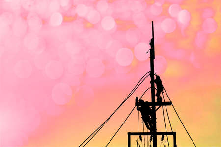 silhouette electric worker working on pole with abstract backgroundの写真素材