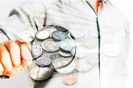 business man using magnifing glass looking group of coinsの写真素材