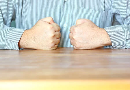 the worker doing double handful on table in front of his breastの写真素材