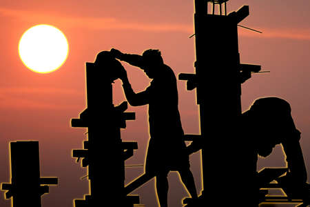 silhouette abor working in construction site with sun set  abstract nature backgroundの写真素材