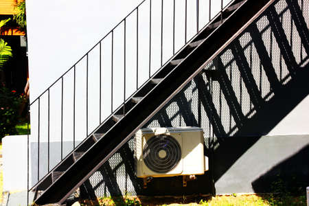 the outdoor black steel stairs install out side building with air compressorの写真素材