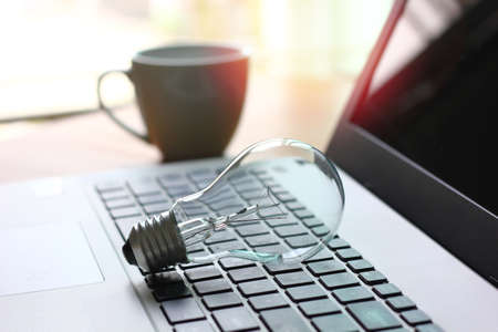 light bulb on laptop with blur background , idea working conceptの写真素材