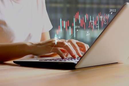 Asian woman worker using laptop searching start up business trend after the economic recovery ,...