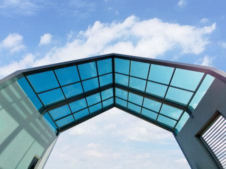 Translucent roof structure with bright blue skyの写真素材