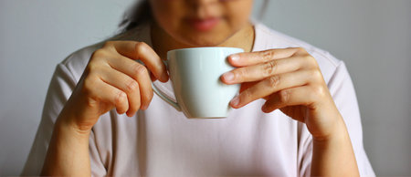 Close up of a woman holding a cup of coffee in her hands