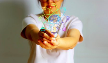 Woman hand holding a light bulb with social media icons and symbols.の写真素材