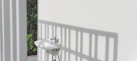 shadow on white ceramic sink install on the wall.の写真素材