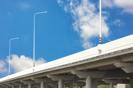 concrete structure elevelated local road against blue sky white cloudの写真素材