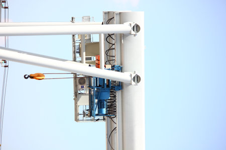 close up  shot outdoor two electric hoists motor set on beam against blue skyの写真素材
