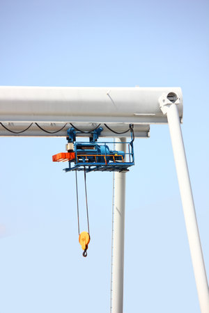 outdoor two electric hoists motor set on beam against blue skyの写真素材