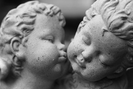 close up gray sculpture of a boy and girl little angle in a loving mood decoration in gardenの写真素材