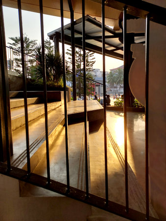 View through the fence of the cement staircase with light falling through the roof vents, the architect design conceptの写真素材