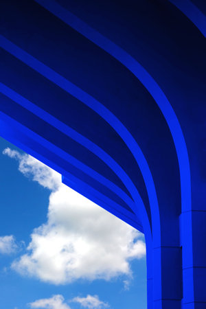 concrete structure curve shape blue gradient color on blue sky white cloud backgroundの写真素材