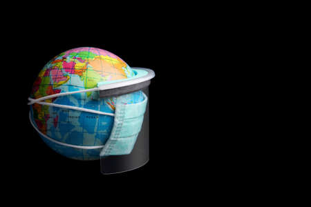 world globe with diy face mask and diy face shield on black background with copy space, coronavirus / covid19 protection conceptの写真素材
