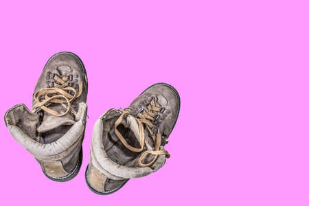 Travel shoes, old shoes, hiking shoes on a pink background.の写真素材