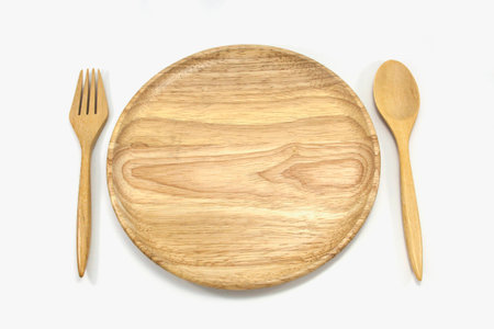 Wooden plate and pair spoon fork isolated on white backgroundの写真素材