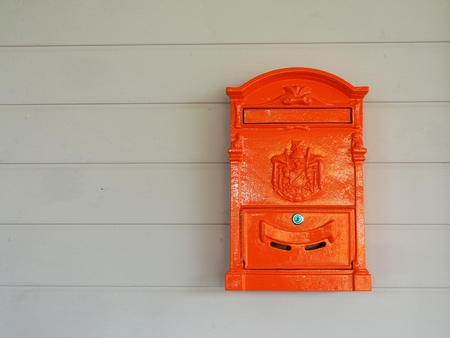 Red mailbox in retro style with brown wood background.の写真素材