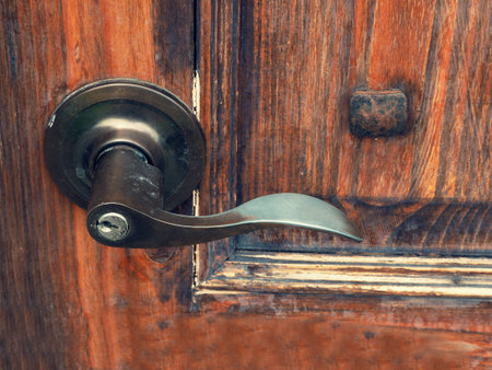 The old metal door handle on the wooden doorの写真素材