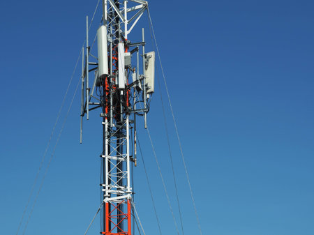 Telecommunication tower with antennas with blue skyの写真素材